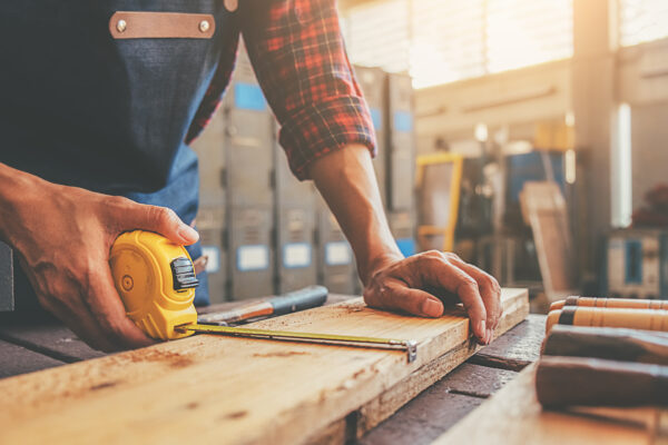 Carpenter working with equipment on wooden table in carpentry shop. woman works in a carpentry shop.